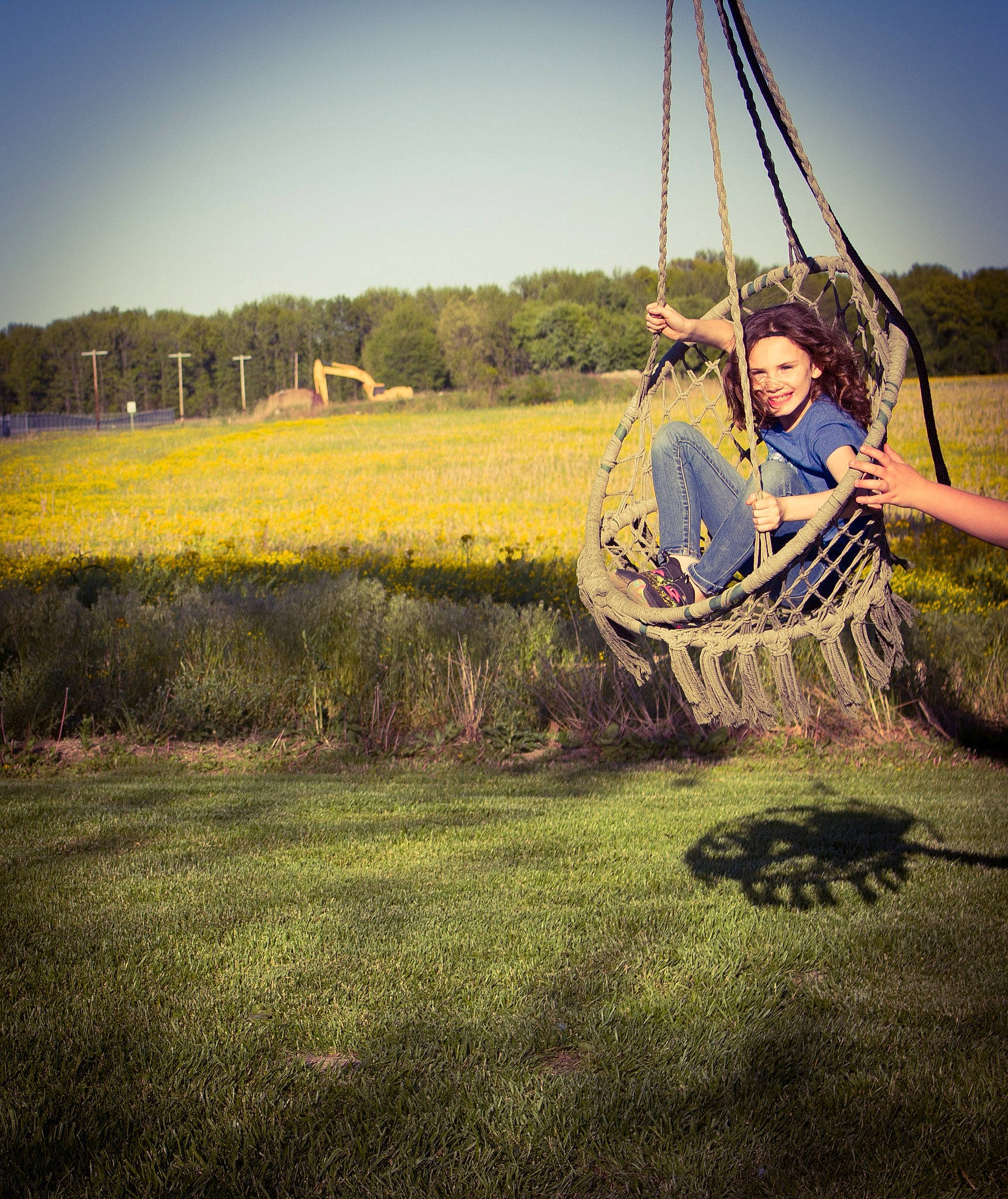 Emma is registered to the contest to win money with this photo: automotive_tire, field, fun, grass, grassland, happy, joy, landscape, leisure, meadow, outdoor_play_equipment, people_in_nature, person, plant, pole, recreation, rope, sky, swing, tints_and_shades