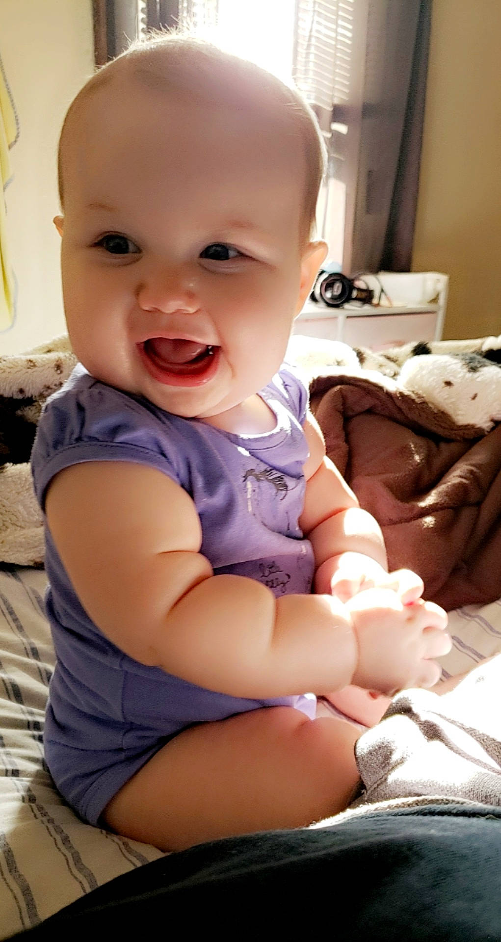 Phoebe is registered to the contest to win money with this photo: arm, baby, baby_toddler_clothing, cheek, child, comfort, facial_expression, finger, happy, joint, mouth, nose, person, product, sitting, skin, sleeve, smile, thigh, thumb