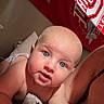 Nolan joined the competition — help win amazing prizes! baby, blue_eyes, child, indoor, blanket, bed, person, face, curious, skin, head, expression, human, young, infant, comfort, red, banner, logo, closeup