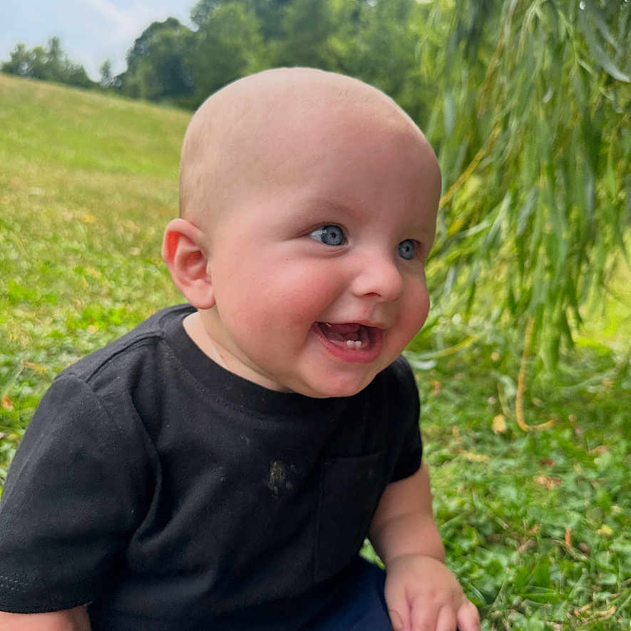 Nolan joined the competition — help win amazing prizes! baby, child, smiling, outdoor, grass, greenery, nature, blue_eyes, black_shirt, shorts, happy, sitting, cute, portrait, infant, sunlight, daylight, young, person, park