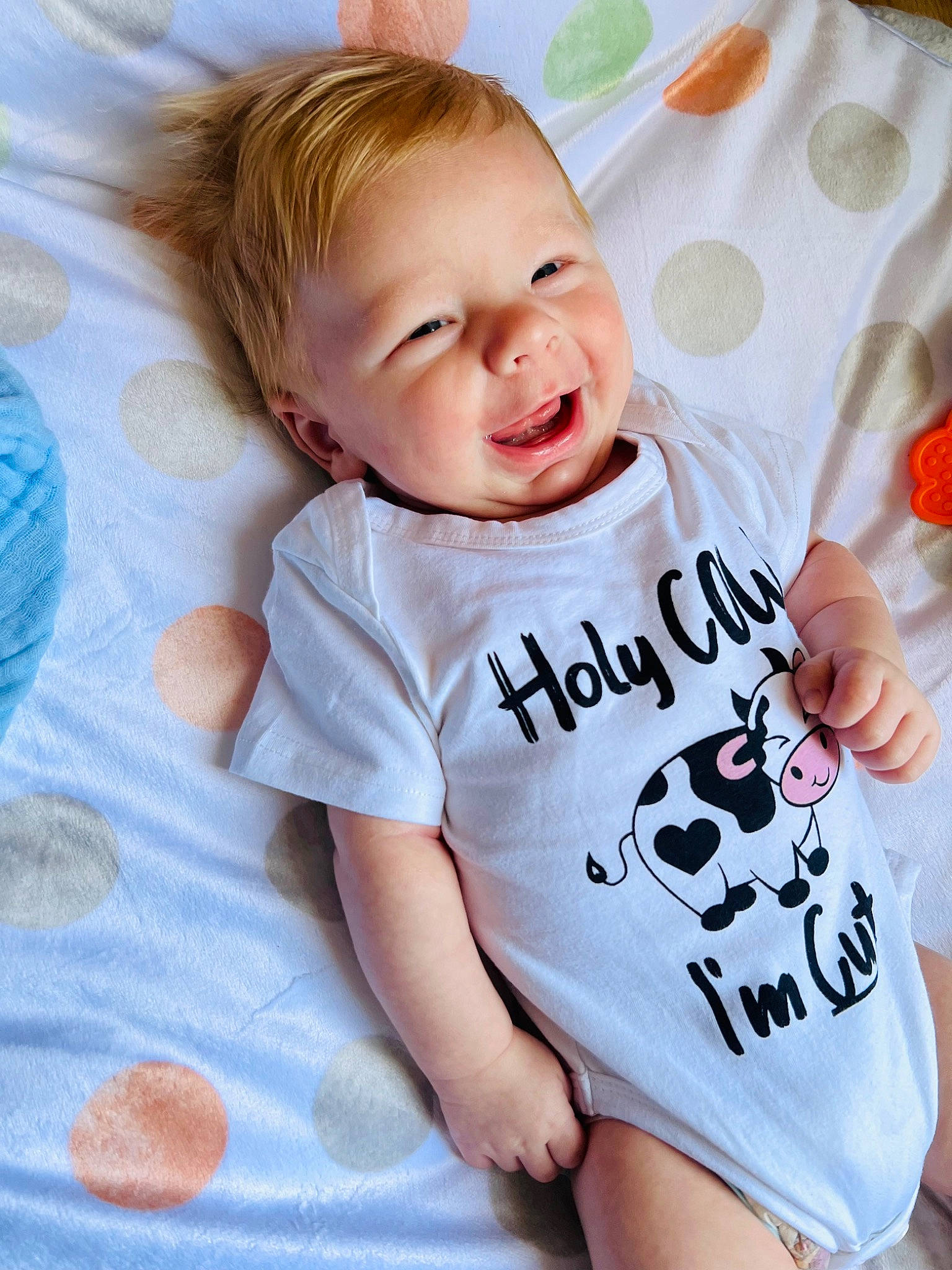 Korbin is registered to the contest to win money with this photo: baby, baby_toddler_clothing, cheek, child, comfort, eye, face, font, fun, gesture, happy, head, linens, pattern, person, product, skin, sleeve, smile, t_shirt