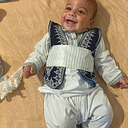 Adam participe au concours pour gagner de l'argent avec cette photo : baby, smiling, lying_down, traditional_clothing, embroidery, blanket, indoors, tissue, tube, happy, child, person, foot, hand, fabric, cute, portrait, infant, clothing, relaxed