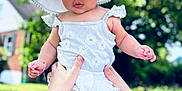 Rosalia is registered to the contest to win money with this photo: baby, child, hat, white_clothing, outdoor, grass, hands, person, summer, cute, portrait, sun_hat, nature, greenery, daylight, infant, holding_hands, daisy_pattern, shorts, skin