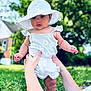 baby, child, hat, white_clothing, outdoor, grass, hands, person, summer, cute, portrait, sun_hat, nature, greenery, daylight, infant, holding_hands, daisy_pattern, shorts, skin