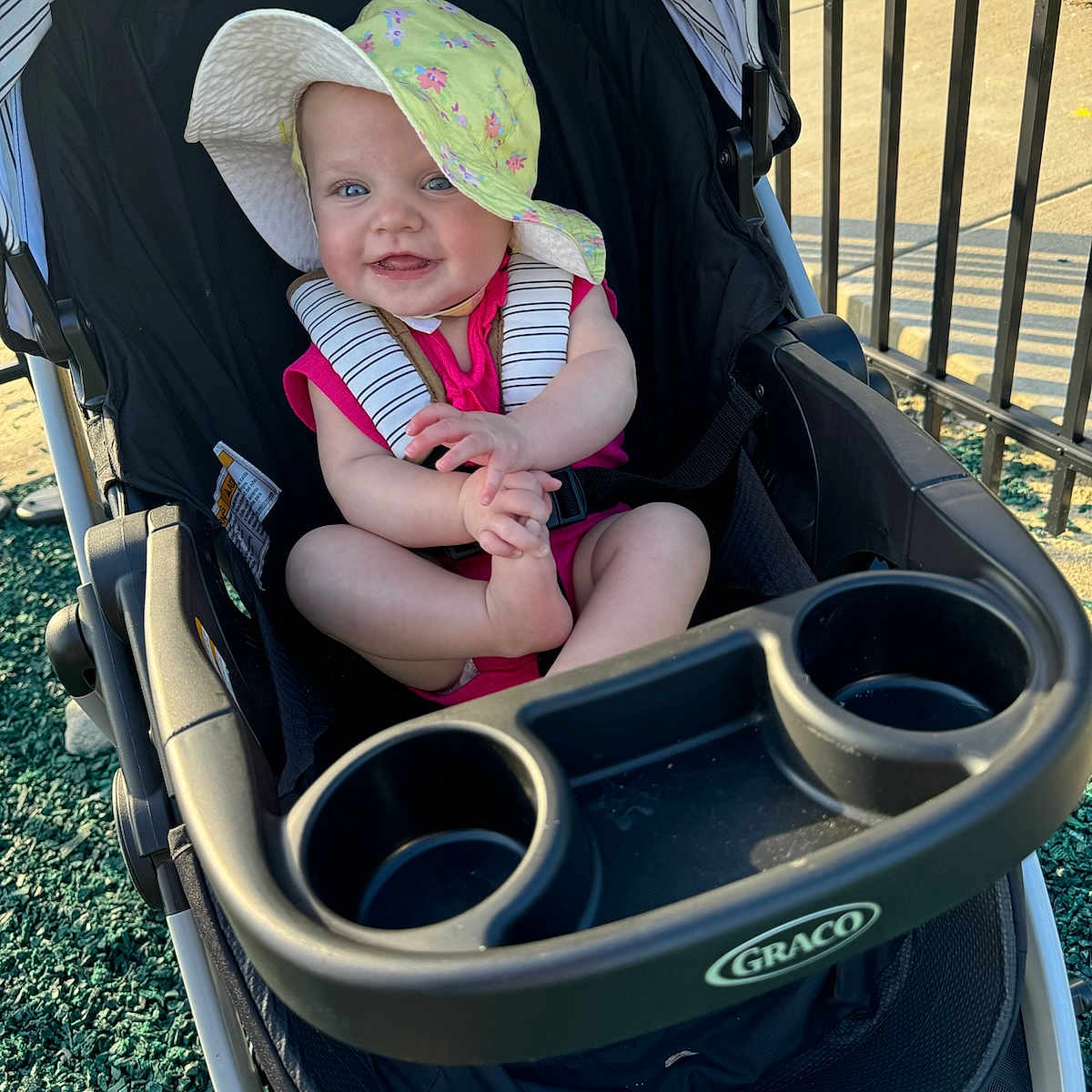 Elaina joined the competition — help win amazing prizes! accessories, baby, baseballcap, cap, clothing, face, grass, hat, head, nature, outdoors, park, person, photography, plant, portrait, stroller, summer, sunglasses, sunhat