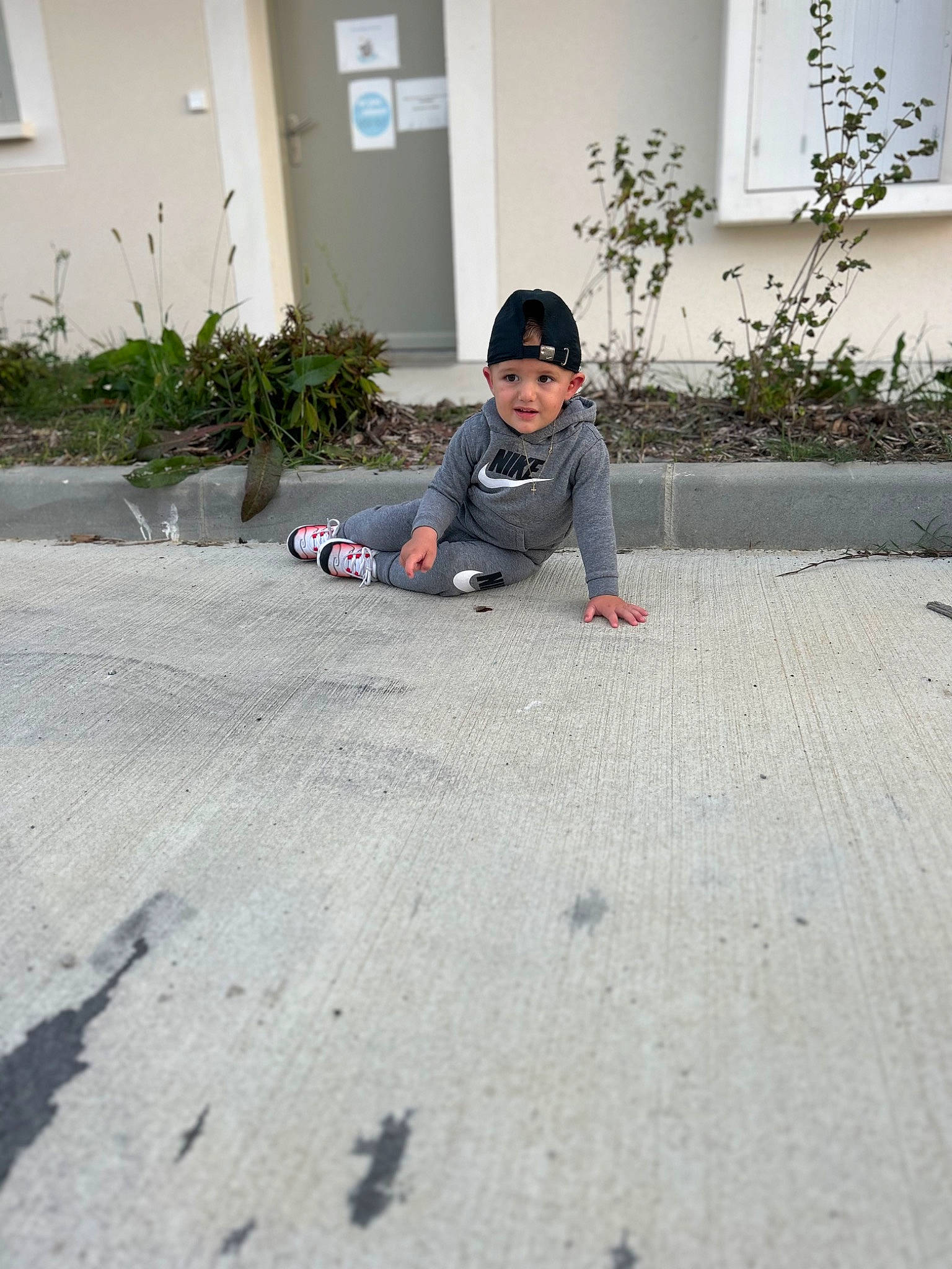 Diego participe au concours pour gagner de l'argent avec cette photo : asphalt, city, cobblestone, concrete, driveway, floor, flooring, fun, grass, grey, headwear, landscape, leisure, person, plant, road, road_surface, shadow, sidewalk, sitting