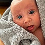 baby, blue_eyes, blanket, closeup, curious, face, fluffy, gray, hand, infant, mouth_open, person, portrait, skin, soft, towel, wrapped, wide_eyes, young_child, indoor