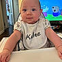baby, high_chair, bib, indoor, child, blue_eyes, cute, infant, television, cartoon, person, clothing, table, furniture, smiling, face, arm, hand, home, expression