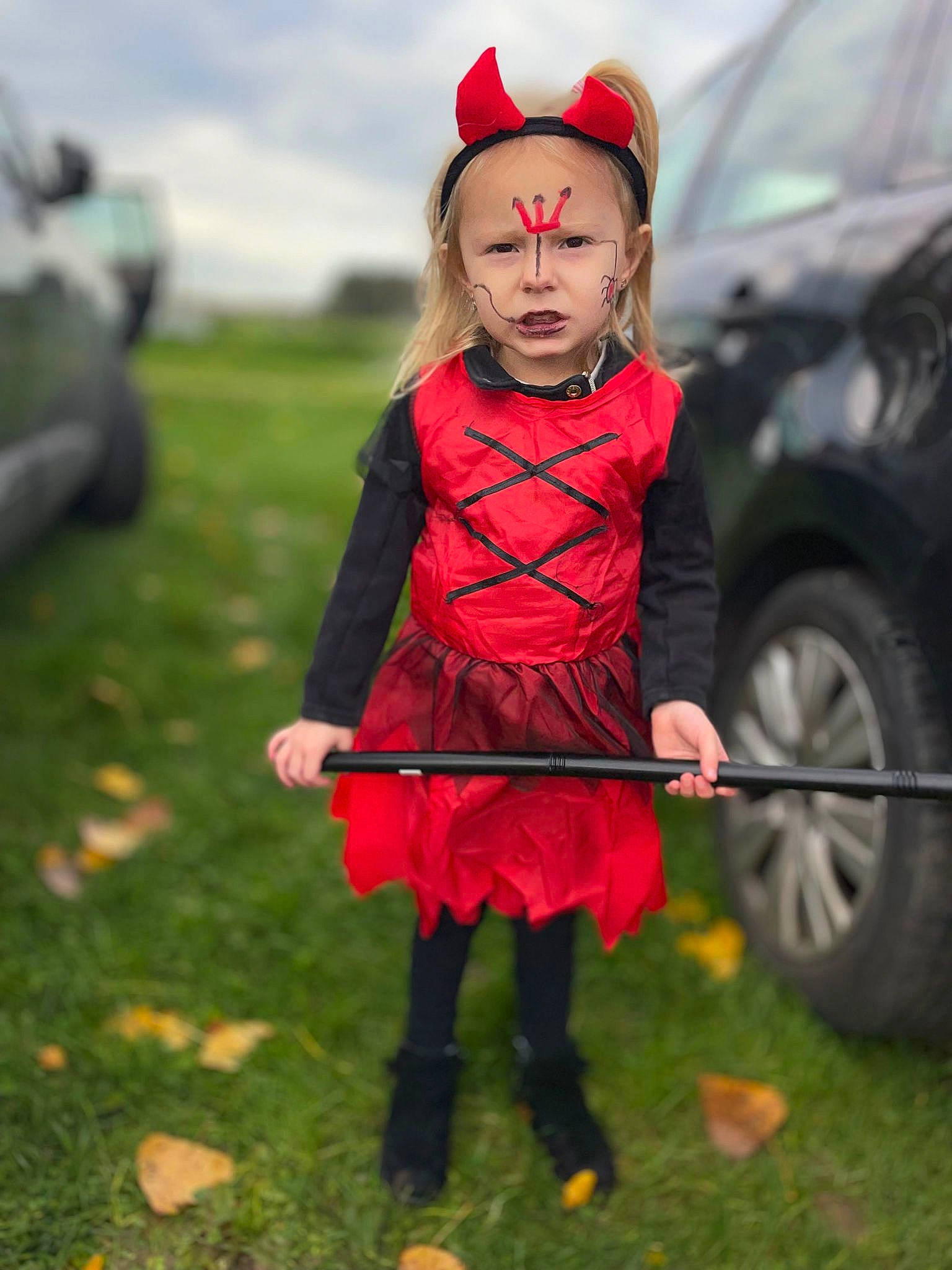 Rose participe au concours pour gagner de l'argent avec cette photo : automotive_tire, car, child, costume, dress, event, fictional_character, fun, grass, grassland, happy, magenta, people_in_nature, person, personal_protective_equipment, sky, tire, toddler, tradition, vehicle