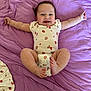 Jazlyn joined the competition — help win amazing prizes! baby, infant, smiling, lying_down, purple_bedspread, strawberry_pattern, clothing, arms_outstretched, feet, happy, cute, person, skin, head, face, indoors, bed, fabric, child, toddler