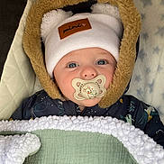 élio participe au concours pour gagner de l'argent avec cette photo : baby, pacifier, hat, jacket, blanket, face, blue_eyes, infant, cute, warm_clothing, fur_hood, sleeping_bag, portrait, child, indoors, soft_texture, star_pattern, cozy, winter_wear, newborn