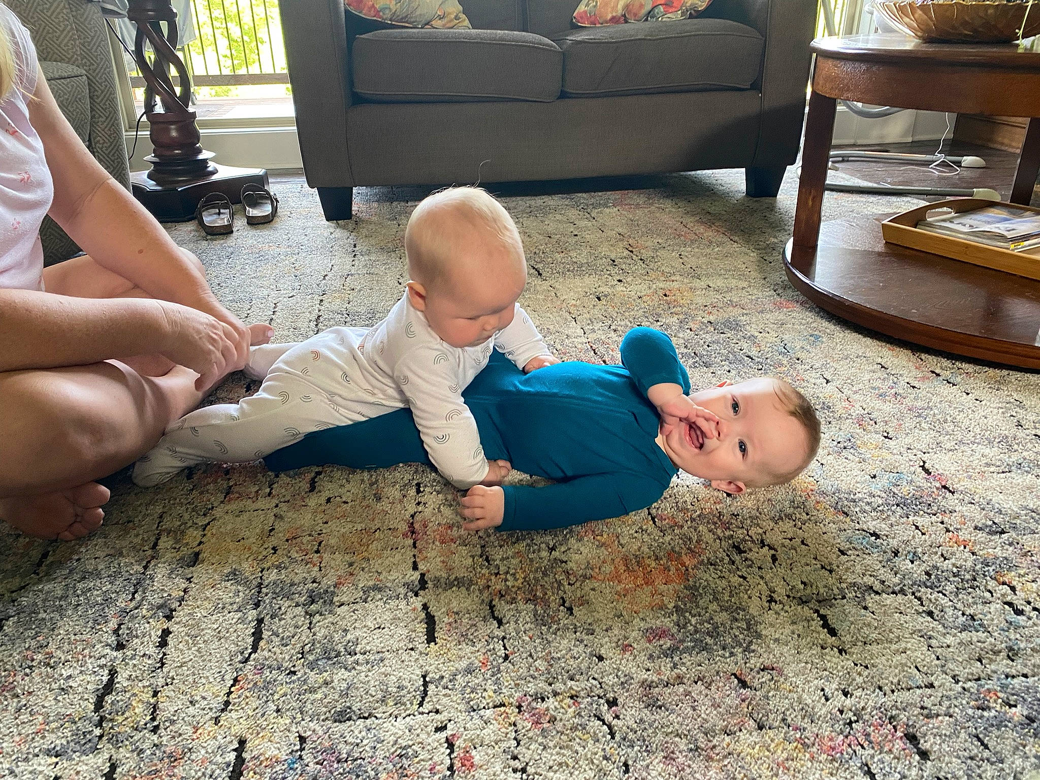 Alan is registered to the contest to win money with this photo: baby, child, comfort, couch, floor, flooring, foot, fun, hardwood, human_leg, knee, lap, leg, leisure, living_room, person, shorts, sock, thigh, toddler