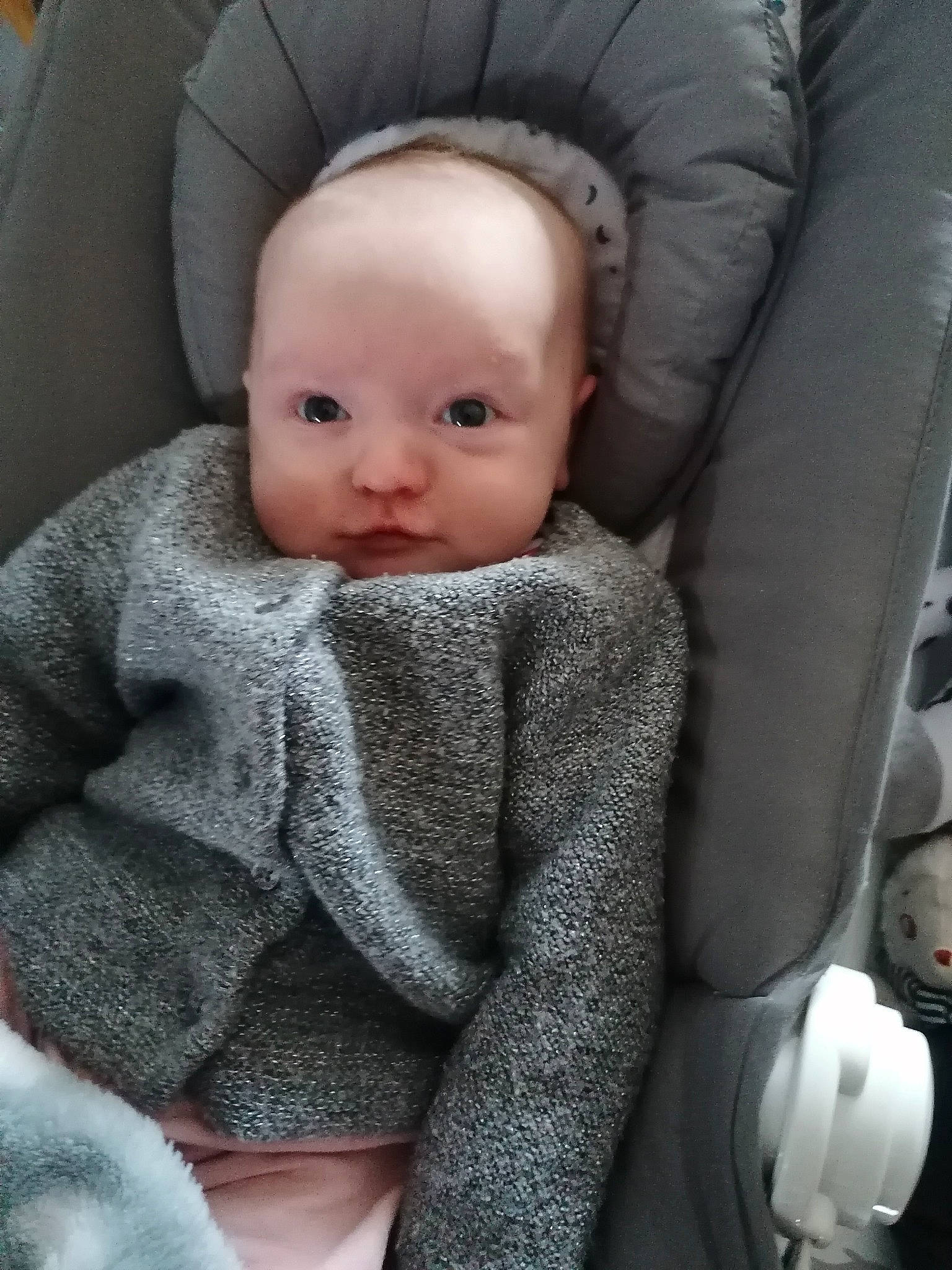 Clémence a rejoint le concours — aidez-le/la à gagner de superbes lots ! baby, baby_products, baby_toddler_clothing, car_seat, car_seat_cover, cheek, child, comfort, grey, knit_cap, lip, person, product, seat_belt, sitting, skin, sleeve, textile, toddler, wool