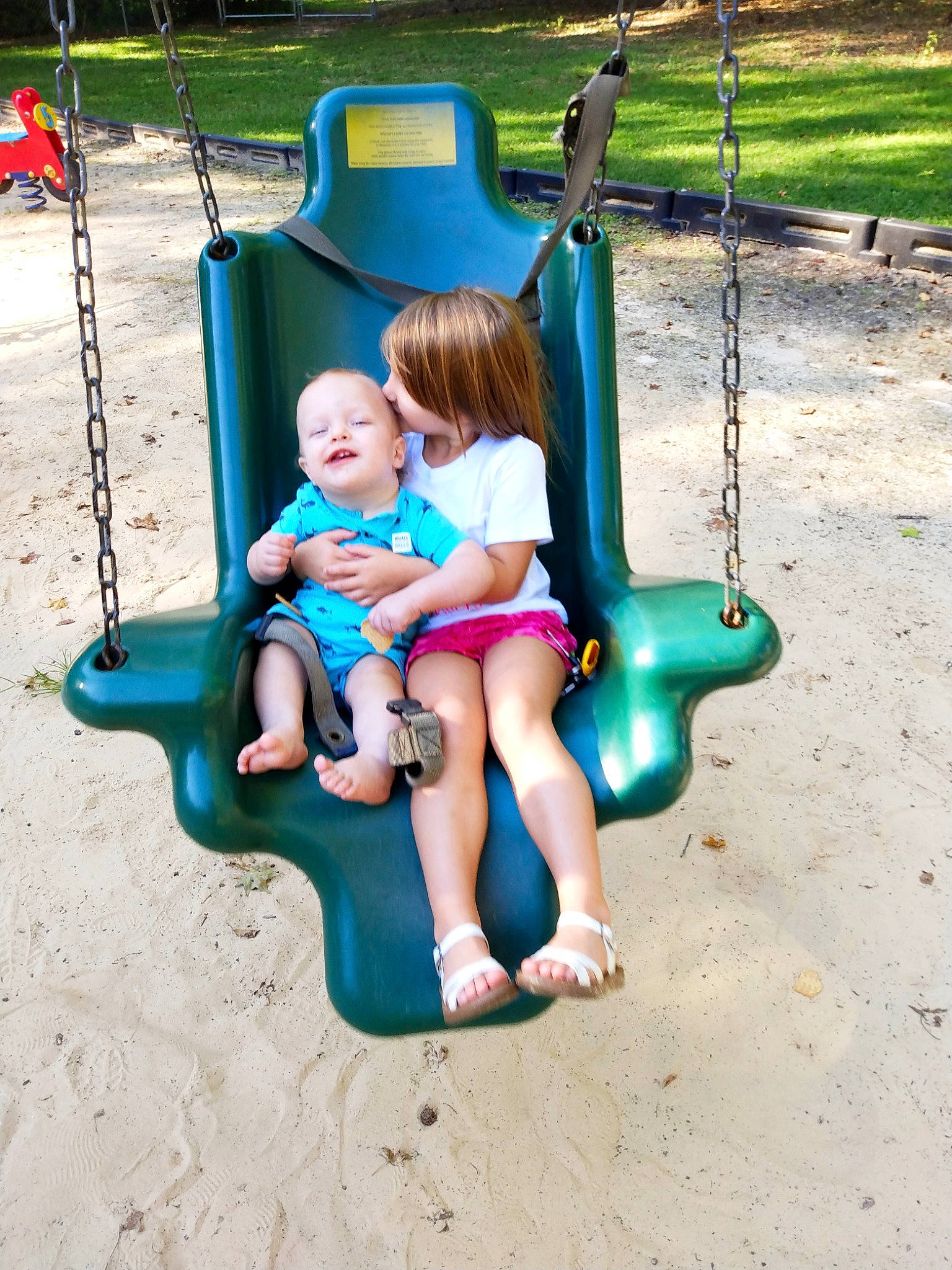 Paisleigh joined the competition — help win amazing prizes! aqua, baby, baby_toddler_clothing, child, chute, city, foot, fun, grass, happy, lap, leisure, outdoor_play_equipment, person, play, playground, playground_slide, recreation, sitting, swing