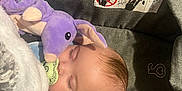Axel is registered to the contest to win money with this photo: baby, blanket, car_seat, child, closeup, clothing, cozy, cute, fabric, face, head, indoor, infant, pacifier, peaceful, purple, resting, sleeping, soft_toy, stuffed_animal