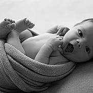 Leandro participe au concours pour gagner de l'argent avec cette photo : baby, newborn, infant, black_and_white, wrapped, towel, cute, portrait, expression, skin, face, feet, hands, lying_down, soft_texture, monochrome, closeup, adorable, child, studio