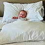 baby, bed, pillow, blanket, white, smiling, infant, comfort, sleeping_area, child, cute, indoor, rest, cozy, soft, person, clothing, head, relaxation, young