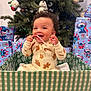 Leilani joined the competition — help win amazing prizes! baby, child, smiling, candy_cane, christmas_tree, christmas_ornaments, presents, gift_boxes, holiday, festive, onesie, plush_toy, decorations, curly_hair, green_box, indoor, celebration, joyful, cute, happy