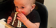 Seth joined the competition — help win amazing prizes! child, toddler, baby, cake, chocolate_cake, eating, highchair, crumbs, frosting, messy, hands, face, portrait, indoor, kitchen, dining, tray, curious_expression, snack, candid