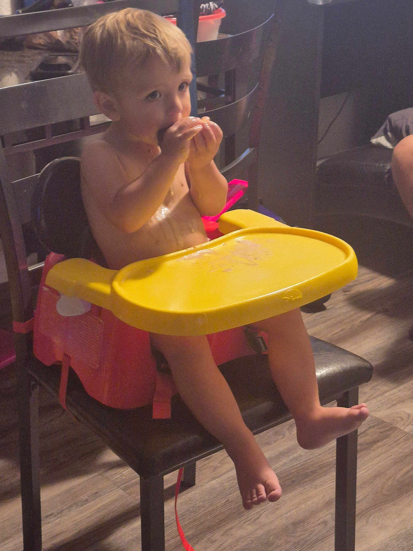 Zander joined the competition — help win amazing prizes! toddler, child, booster_seat, high_chair, eating, snack, indoor, chair, wooden_floor, yellow_tray, furniture, barefoot, curly_hair, young_child, home, casual, person, table, seat, light