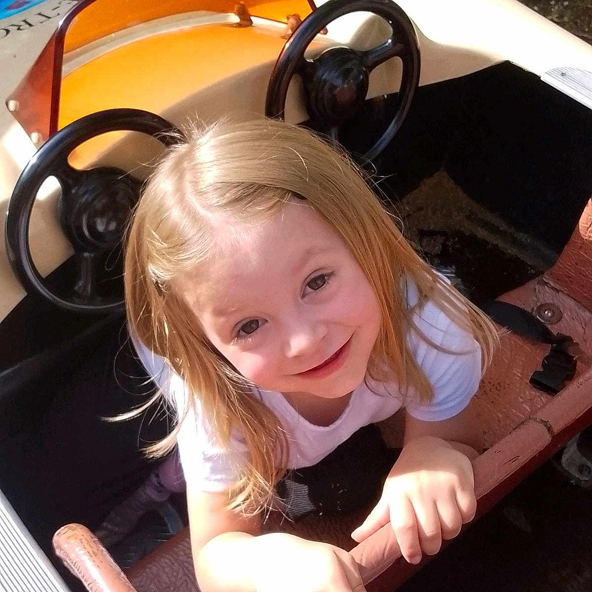 Solange participe au concours pour gagner de l'argent avec cette photo : blonde, child, clothing, face, female, girl, hair, happy, head, machine, outdoors, person, photography, portrait, smile, summer, t_shirt, transportation, vehicle, wheel