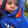 Amin joined the competition — help win amazing prizes! adult, baby, background, blue, child, closeup, curious, face, grass, hand, hoodie, knitted, nature, orange, outdoor, person, portrait, smiling_person, warm_clothing, yellow