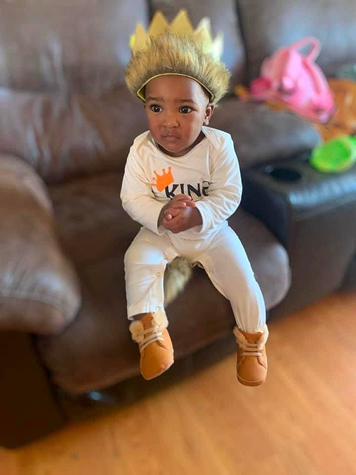 Camden joined the competition — help win amazing prizes! baby, baby_toddler_clothing, child, floor, flooring, foot, fur, happy, hardwood, head, headwear, human_leg, knee, leg, person, sitting, sleeve, sock, thigh, toddler