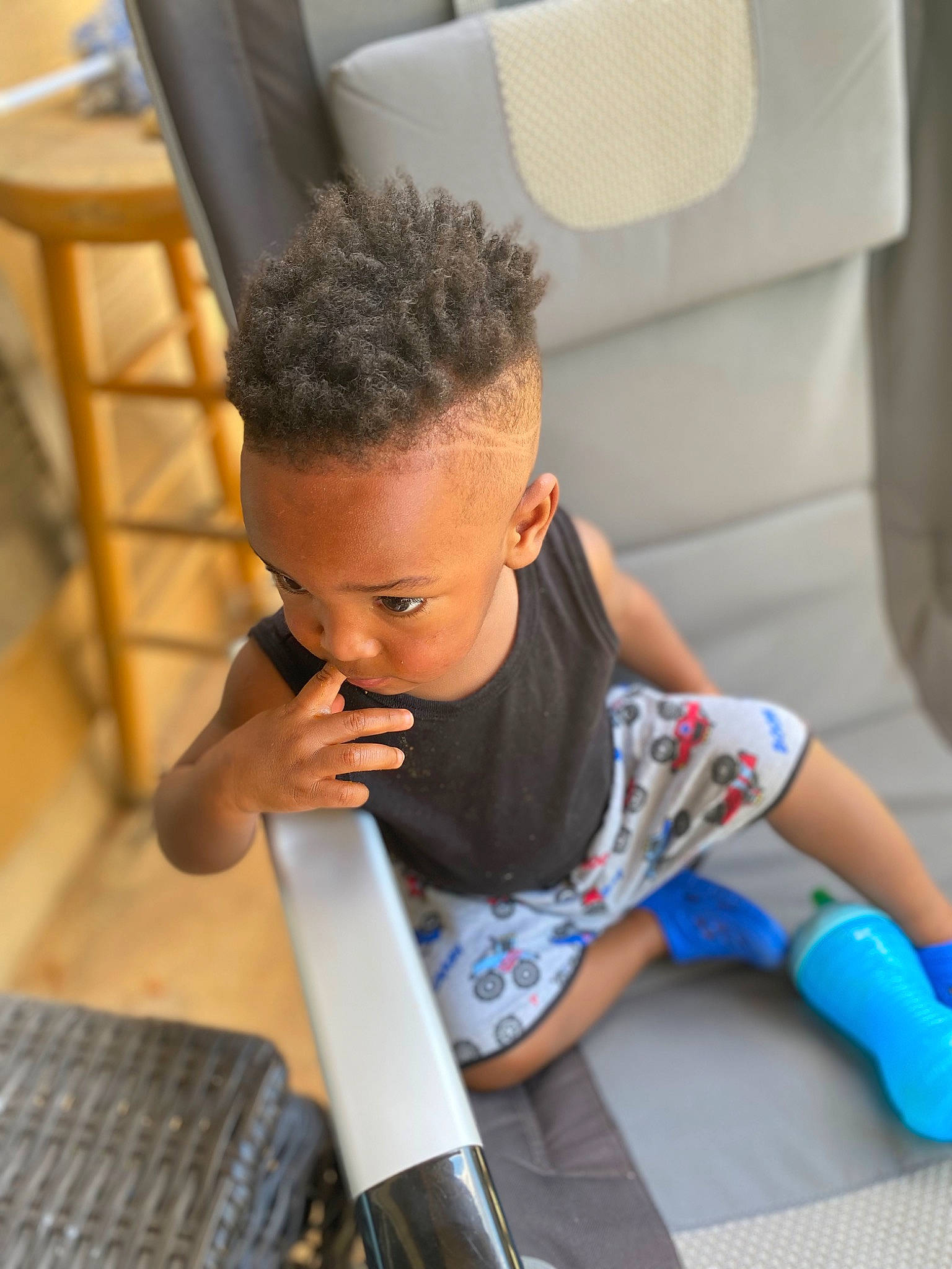 Camden is registered to the contest to win money with this photo: chair, child, comfort, elbow, electric_blue, floor, flooring, happy, hardwood, human_leg, joint, knee, leisure, person, room, sitting, sock, t_shirt, thigh, toddler
