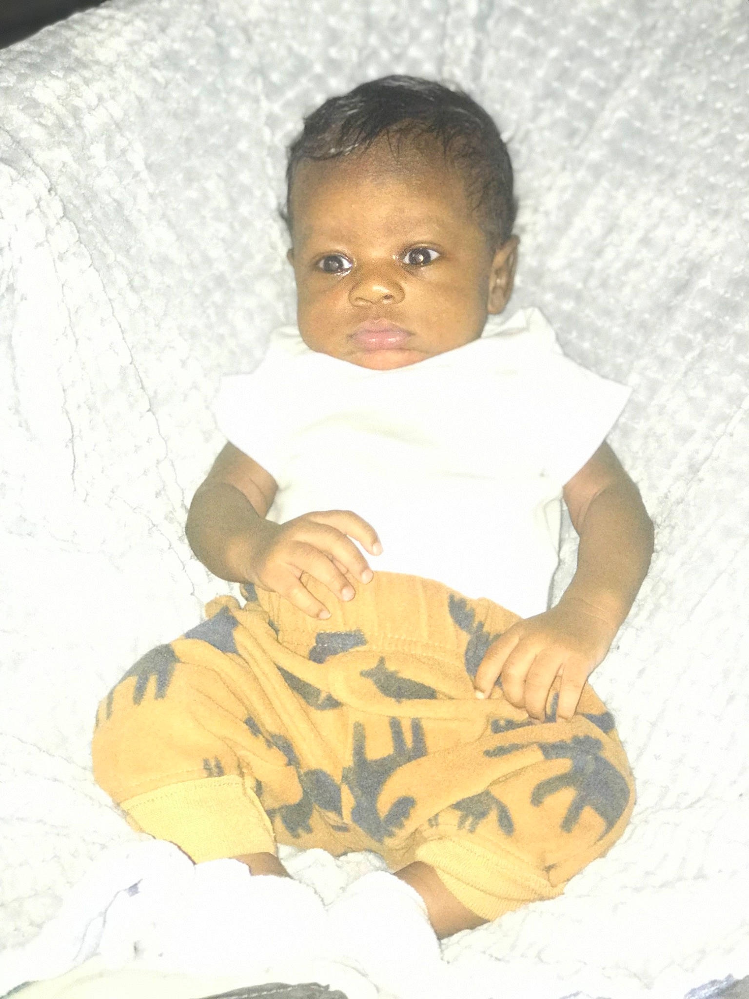 Karson is registered to the contest to win money with this photo: baby, baby_products, baby_toddler_clothing, cheek, child, comfort, face, head, human_body, linens, pattern, person, room, sitting, sleeve, thumb, toddler