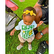 Sayuri is registered to the contest to win money with this photo: toddler, child, grass, outdoor, yellow_bow, tshirt, shorts, sneakers, stroller, adult, tattoo, watch, bracelet, necklace, headband, person, footwear, summer, greenery, family