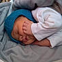 Ayan is registered to the contest to win money with this photo: baby, sleeping, blue_hat, blanket, cozy, infant, hand, peaceful, soft, cute, child, sleepwear, resting, indoors, warm, portrait, newborn, wrapped, comfort, face