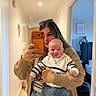 Hudson is registered to the contest to win money with this photo: baby, woman, mirror, selfie, phone, sweater, jeans, hallway, bedroom, teddy_bear, framed_art, smile, sunglasses, hand, person, indoor, cozy, home, carpet, doorway
