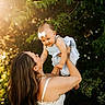 Layken is registered to the contest to win money with this photo: baby, woman, child, outdoor, sunlight, nature, greenery, dress, headband, smile, happy, holding, family, portrait, sunflare, trees, grass, warm, love, playful