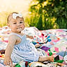 baby, child, girl, bow, dress, quilt, outdoor, grass, sunlight, patchwork, colorful, smile, portrait, sitting, cute, infant, nature, daylight, headband, happy