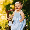 baby, child, smiling, outdoor, sunlight, greenery, dress, headband, chair, grass, happy, portrait, sitting, cute, nature, warm_light, person, summer, innocence, baby_girl