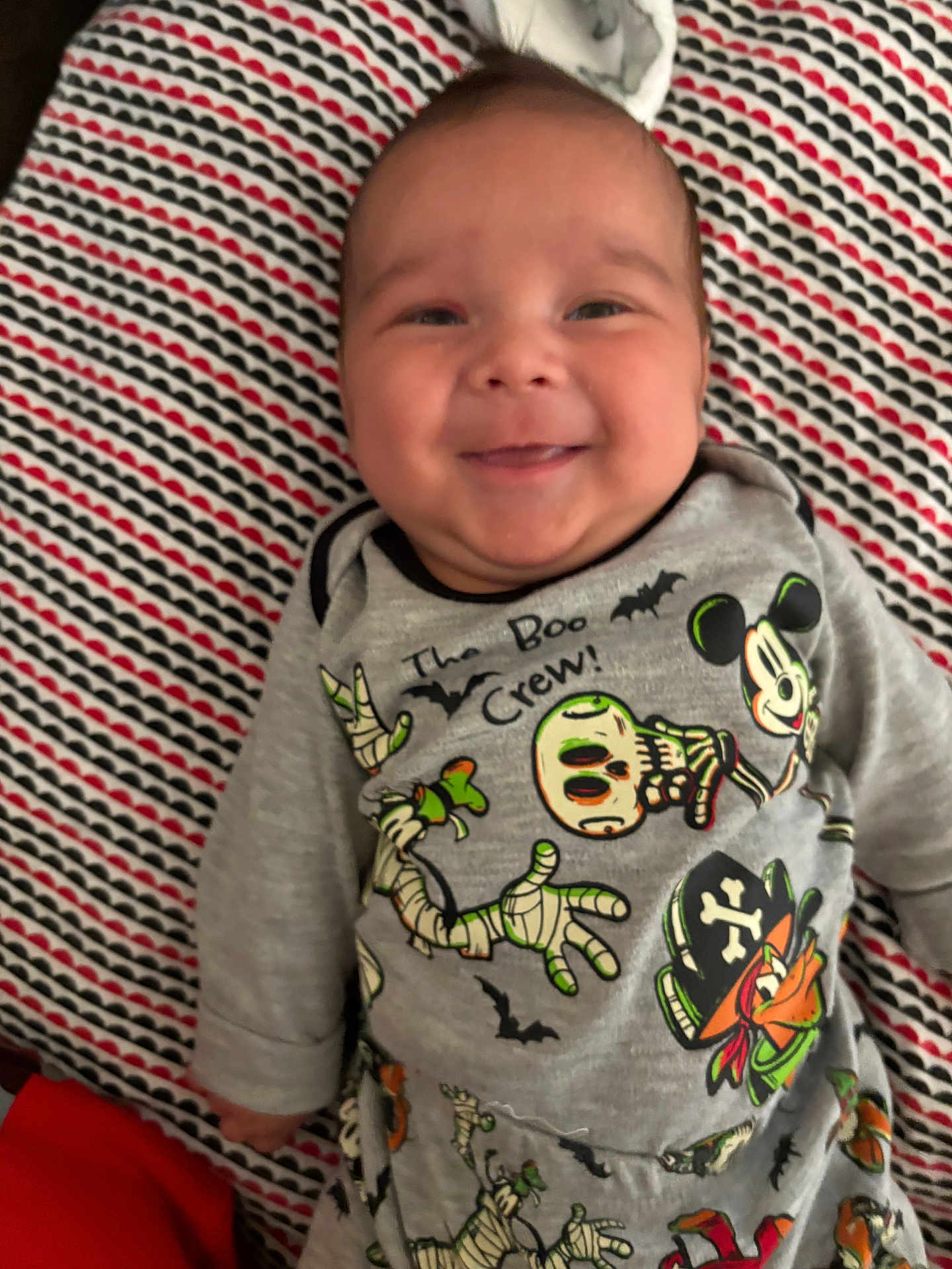 Bobby Ray Coca Iii is registered to the contest to win money with this photo: baby, infant, smiling, face, clothing, onesie, patterned_blanket, cartoon_characters, mickey_mouse, halloween, skeleton, bats, pirate, cute, lying_down, child, happy, indoor, portrait, young