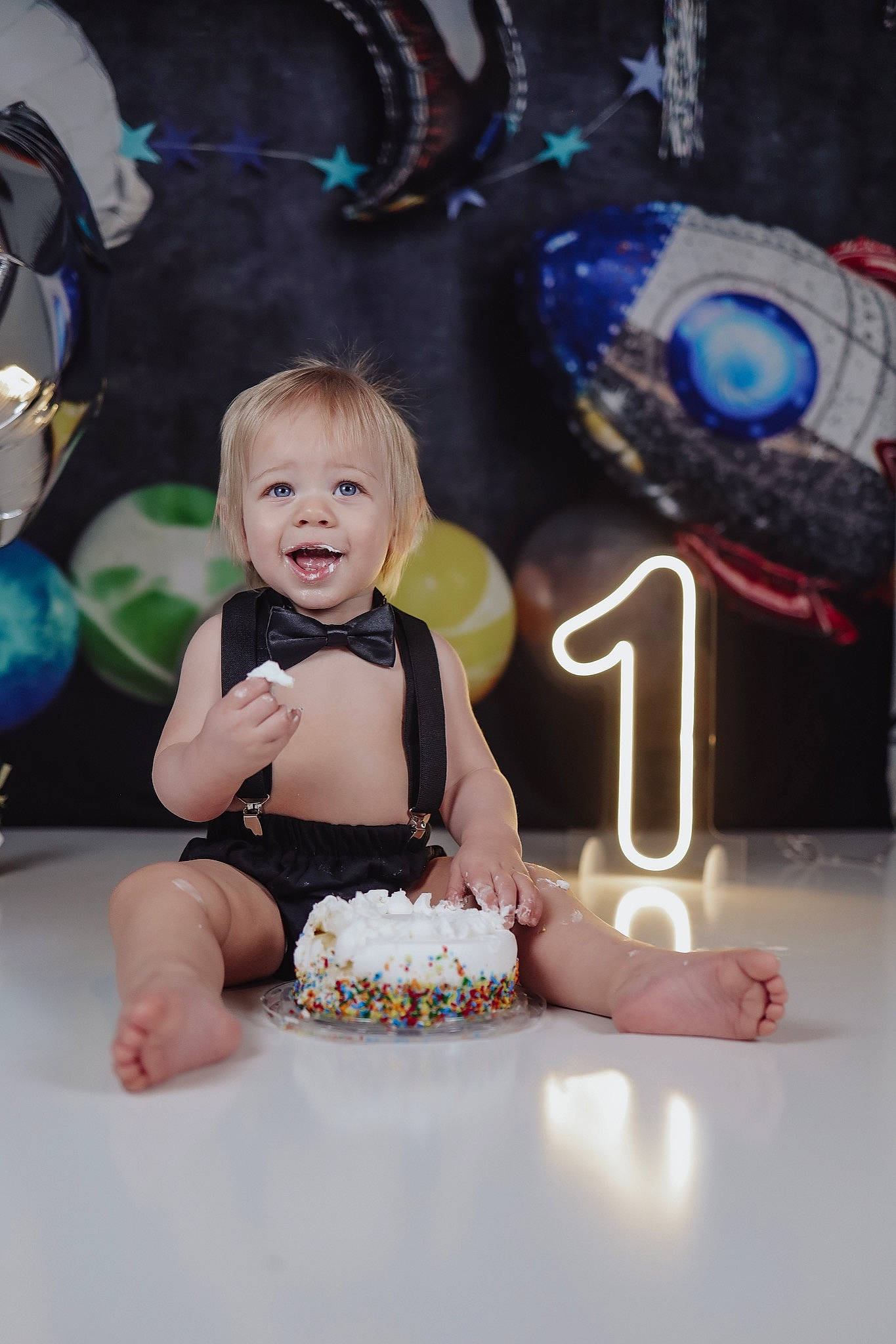 Nolan is registered to the contest to win money with this photo: baby, baby_toddler_clothing, birthday, birthday_cake, blue, cake, cake_decorating, cake_decorating_supply, child, event, food, fun, happy, icing, leisure, person, pink, sitting, smile, sugar_cake