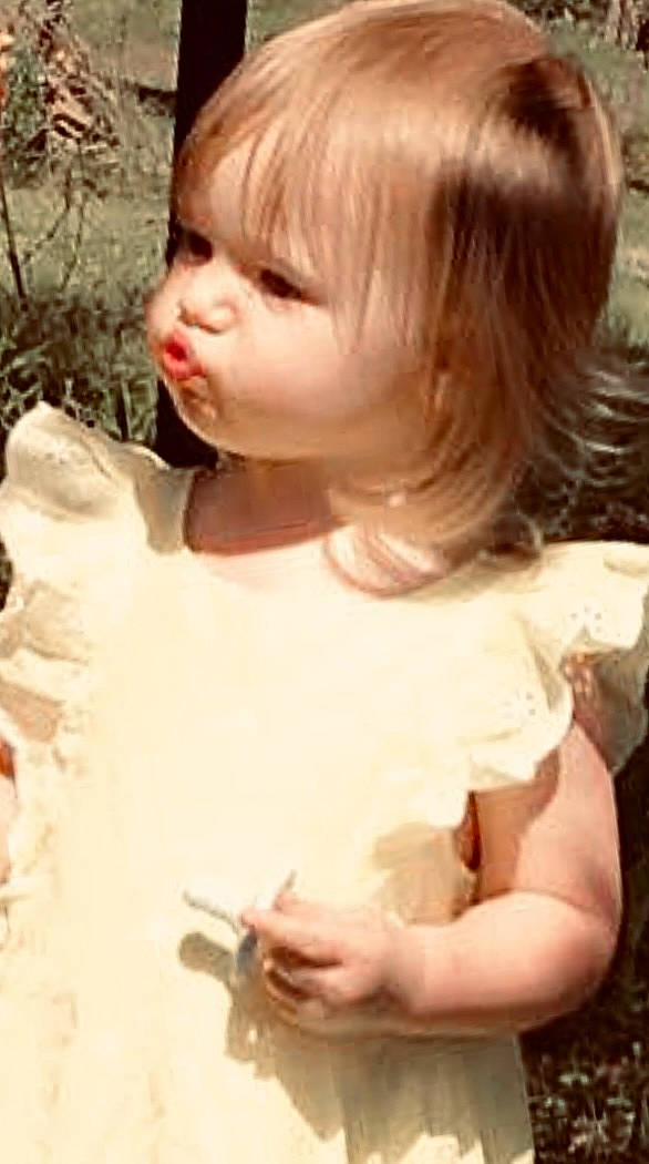 Bristol is registered to the contest to win money with this photo: baby, baby_toddler_clothing, bangs, blond, brown_hair, cheek, chest, child, chin, embellishment, eyelash, gesture, grass, hairstyle, happy, iris, lip, mouth, person, smile