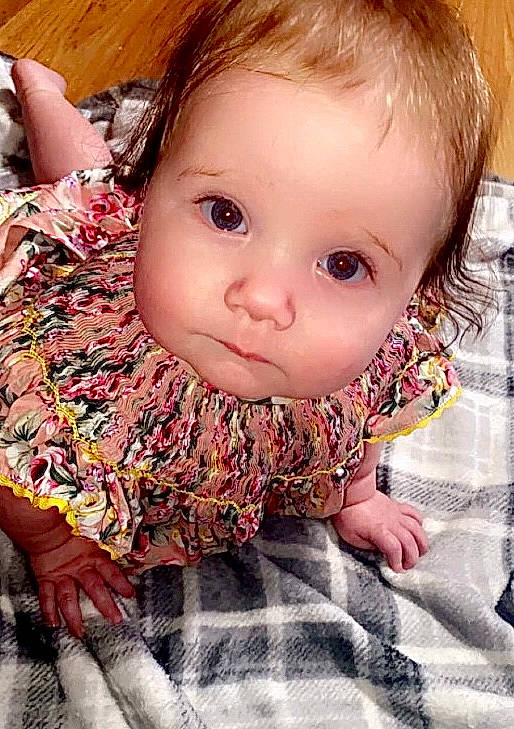 Lyric is registered to the contest to win money with this photo: arm, baby_toddler_clothing, cheek, chin, dress, eye, eyebrow, eyelash, hair, hand, human_body, iris, lip, mammal, mouth, neck, nose, person, skin, sleeve