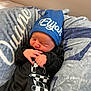 newborn, baby, sleeping, hat, blue_hat, black_outfit, checkered_pattern, blanket, soft_texture, cozy, infant, cute, peaceful, indoors, portrait, child, clothing, resting, baby_boy, closeup