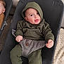 Milo participe au concours pour gagner de l'argent avec cette photo : baby, baby_seat, blanket, carseat, child, couch, cozy, curious, fabric, face, furniture, green_clothing, hoodie, indoor, infant, person, playful, portrait, seatbelt, smiling