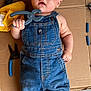 Roman joined the competition — help win amazing prizes! baby, denim_overalls, cardboard, tool, pliers, yellow_cloth, concrete_floor, child, blue_eyes, face, hand, barefoot, curious_expression, workshop, floor, clothing, infant, portrait, holding, indoor