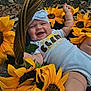 baby, smiling, sunflower, basket, flower, outdoor, headband, happy, child, nature, greenery, white_clothing, cute, infant, summer, plant, portrait, skin, grass, leaf