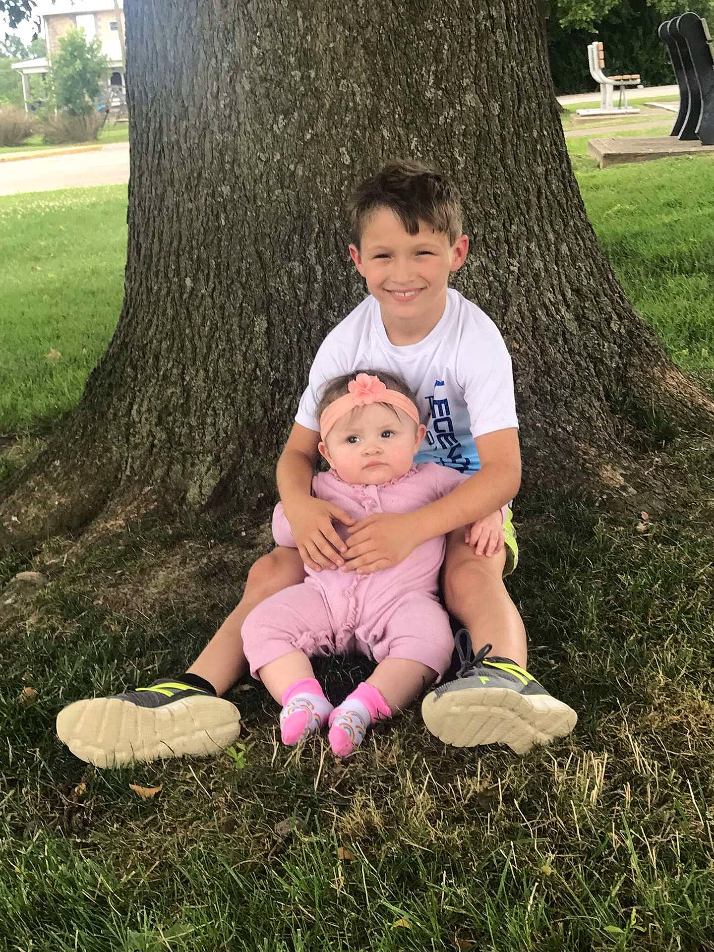 Wyatt is registered to the contest to win money with this photo: face, footwear, grass, green, hairstyle, happy, headwear, joy, leaf, leg, leisure, natural_environment, people_in_nature, person, plant, shoe, shorts, smile, sneakers, sunlight