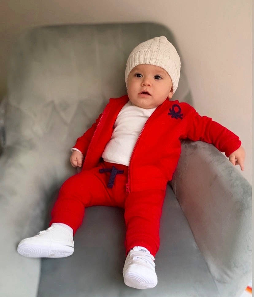 Yoni participe au concours pour gagner de l'argent avec cette photo : art, baby, baby_toddler_clothing, carmine, child, comfort, costume, fictional_character, fur, happy, headwear, human_leg, knee, outerwear, person, pink, product, sitting, sleeve, textile