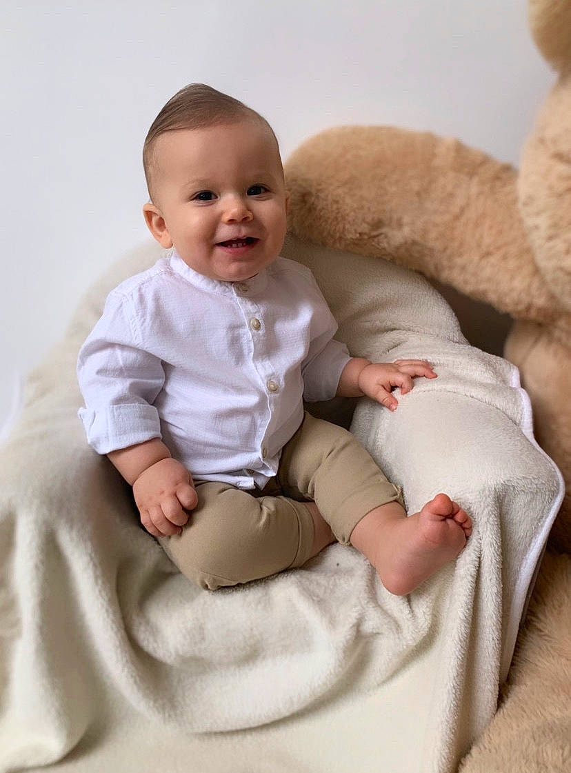 Yoni a rejoint le concours — aidez-le/la à gagner de superbes lots ! baby, baby_toddler_clothing, beauty, cheek, child, comfort, couch, facial_expression, happy, joy, linens, person, pillow, pink, product, sitting, skin, sleeve, smile, stomach