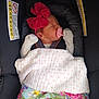 baby, newborn, car_seat, pacifier, headband, red_bow, blanket, polka_dots, floral_pattern, sleeping, infant, child, clothing, seatbelt, closeup, indoors, comfort, safe, cute, resting