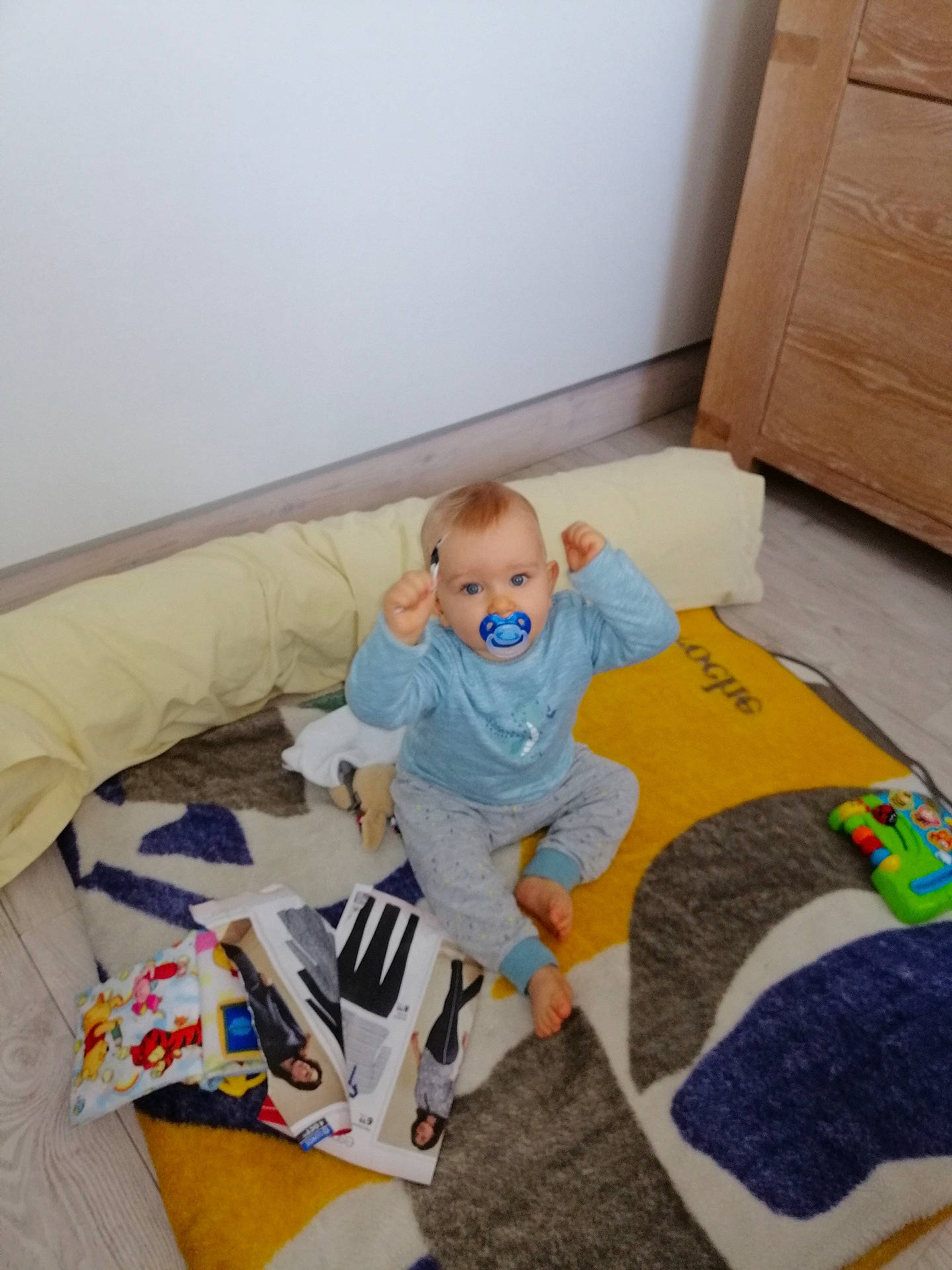Liam a rejoint le concours — aidez-le/la à gagner de superbes lots ! baby, baby_toddler_clothing, child, comfort, couch, floor, flooring, fun, hardwood, linens, living_room, person, pillow, room, sock, stuffed_toy, t_shirt, throw_pillow, toddler, toy