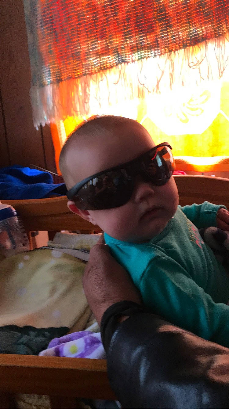 Sierra is registered to the contest to win money with this photo: baby, child, comfort, cool, eyewear, fun, glasses, goggles, leisure, mouth, person, personal_protective_equipment, recreation, room, sitting, sunglasses, tints_and_shades, toddler, vacation, vision_care
