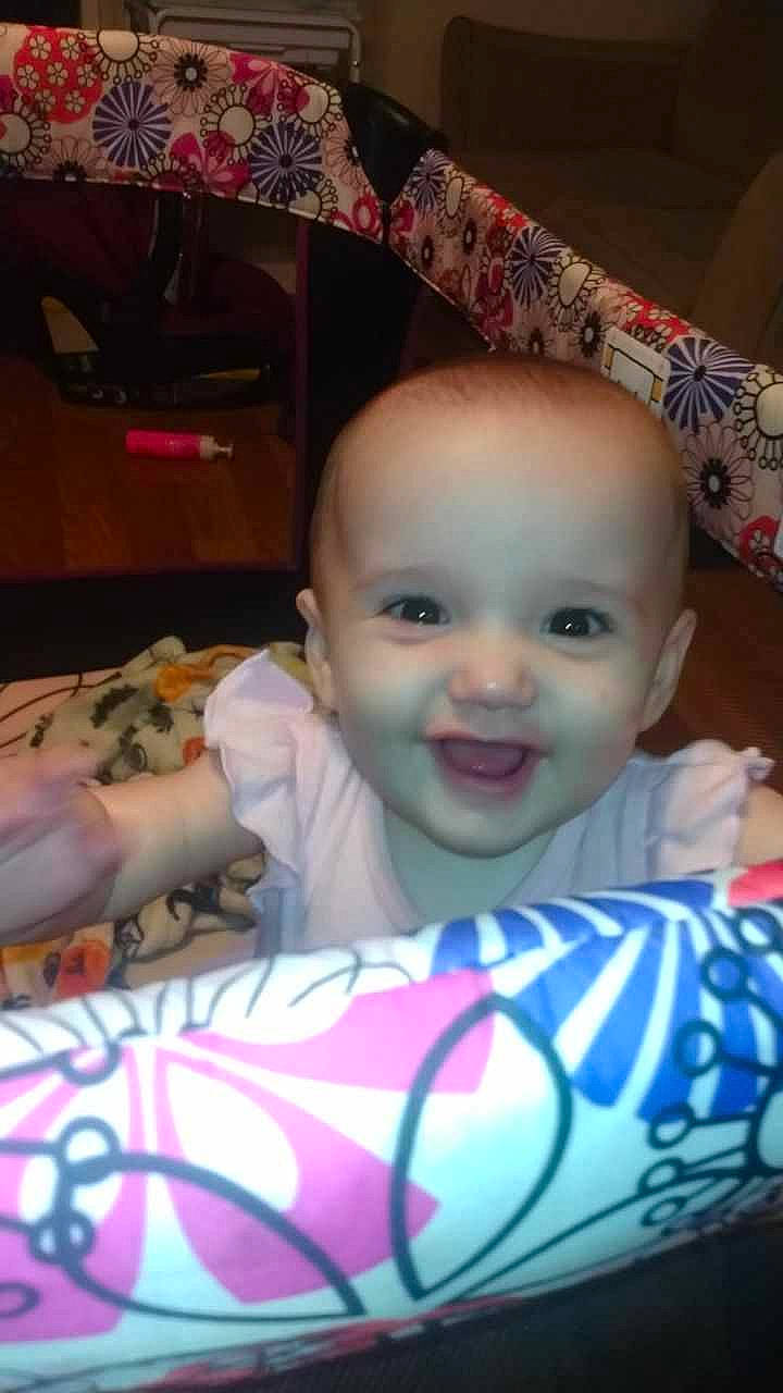 Raelynn is registered to the contest to win money with this photo: baby, baby_products, baby_toddler_clothing, cheek, child, eye, fun, happy, head, iris, joy, linens, magenta, mouth, person, pink, room, sitting, skin, smile